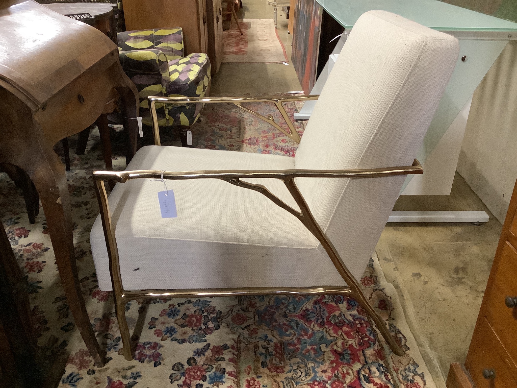 A contemporary brass and natural fabric armchair, width 63cm, depth 77cm, height 72cm